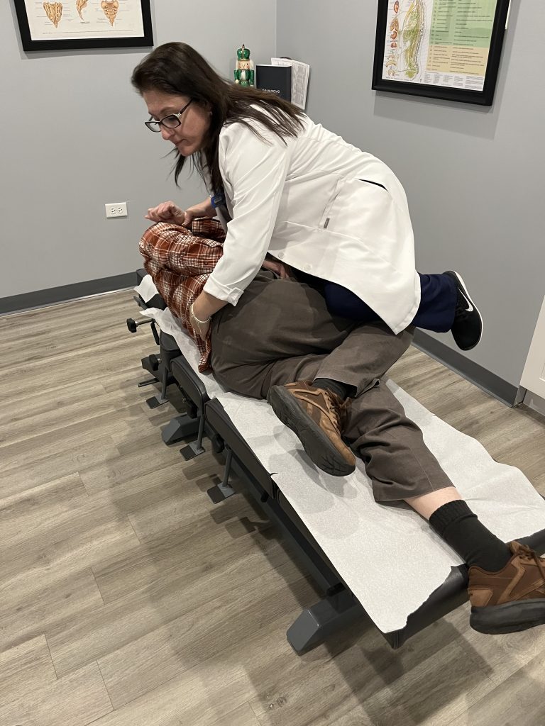Dr. Angie Skokos performing a side-posture lower back adjustment