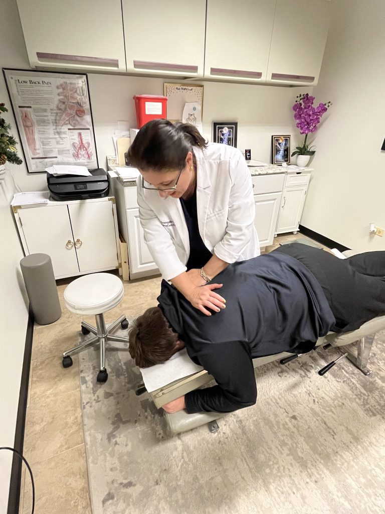 Dr. Angie Skokos performing a mid-back adjustment