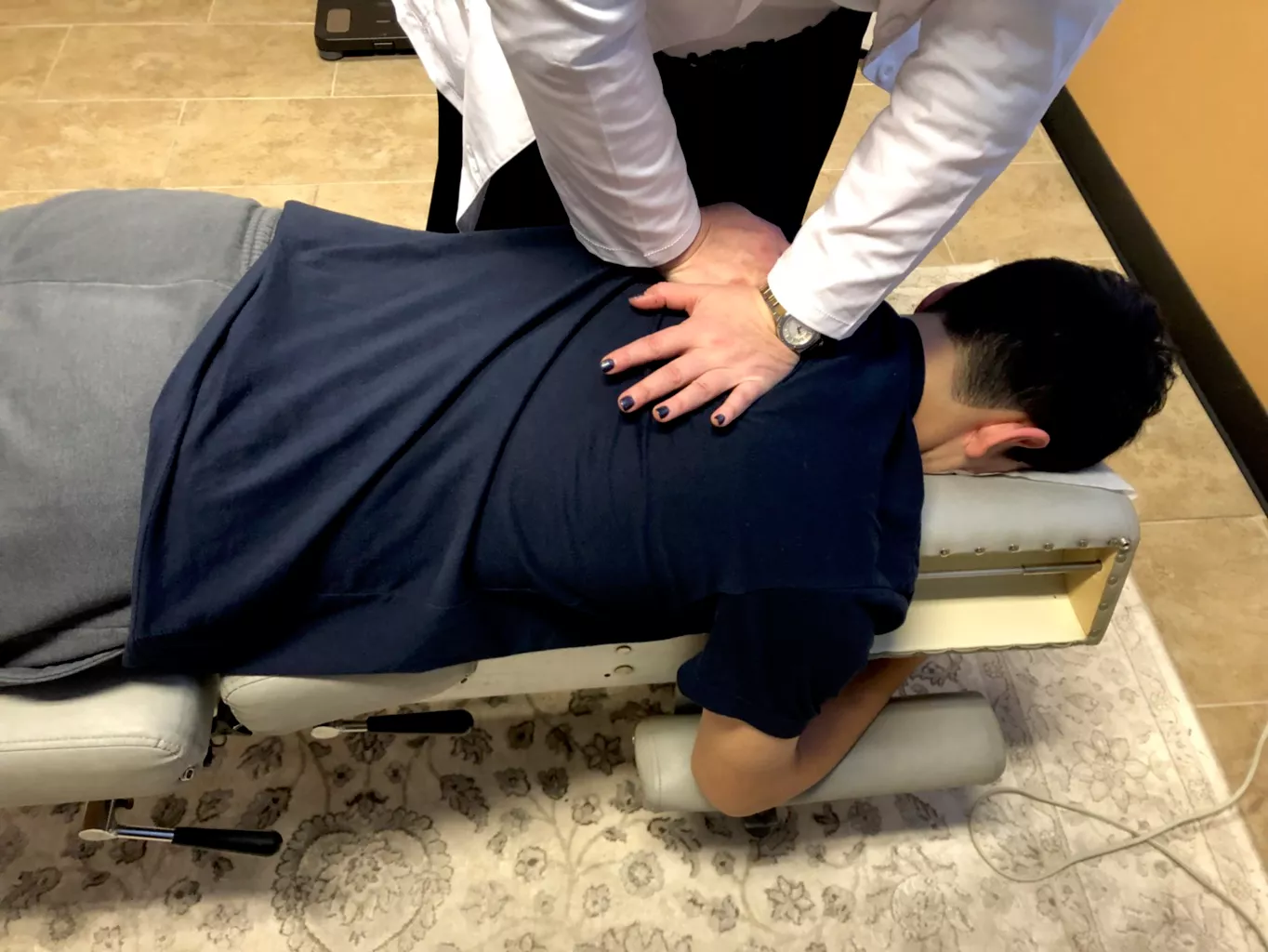 Dr. Angie Skokos performing a chiropractic adjustment on a patient at her Westmont clinic
